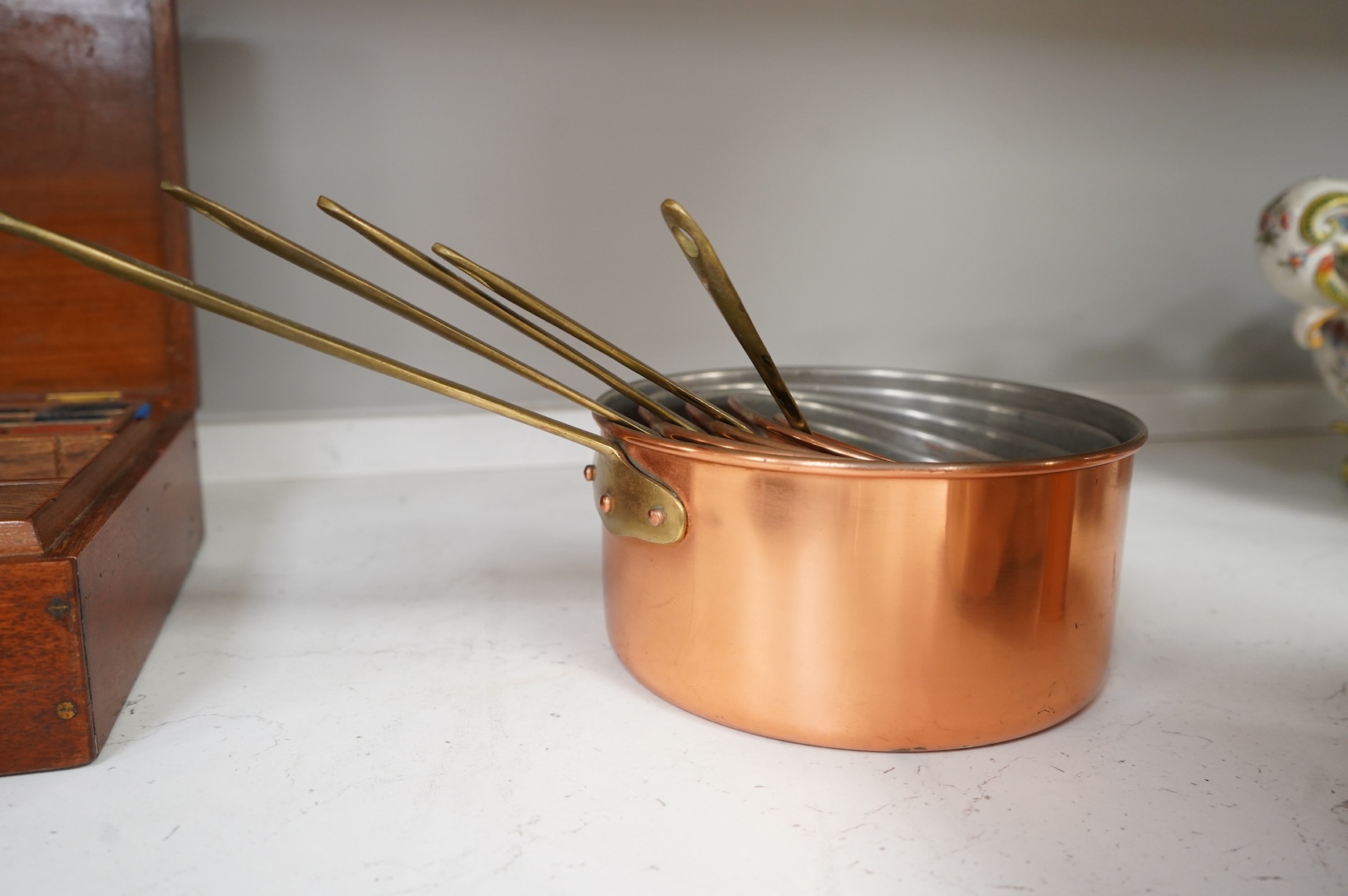 A graduated set of five brass handled copper saucepans, largest 36cm including handle.